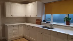 پرده شید زرد خردلی برای آشپزخانه با کابینت سفید و نور کم